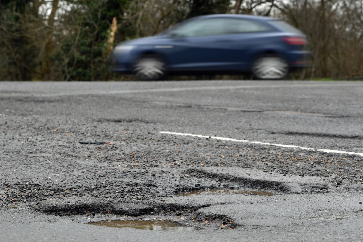 A car passing potholes in a road near Peterborough in Cambridgeshire, England, on April 4, 2018. (Joe Giddens/PA Wire)
