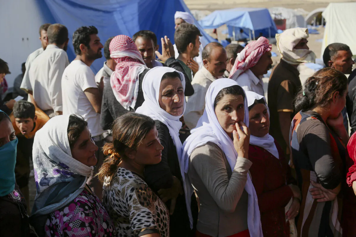 Displaced Iraqis from the Yazidi community gather for humanitarian aid at Nowruz camp, in Derike, Syria, on Aug. 12, 2014. (AP Photo/ Khalid Mohammed)