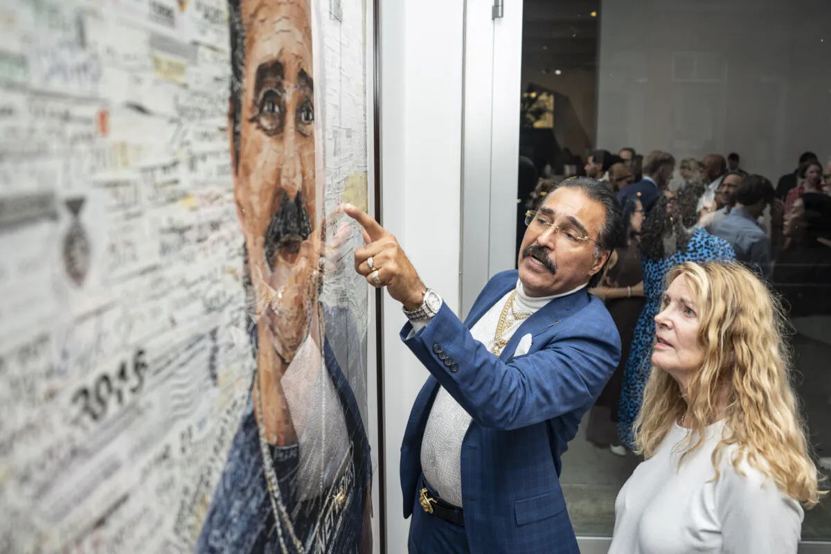 Exoneree Felipe Rodriguez talks with event co-chair Mary Mattingly about a portrait of himself by artist Vik Muniz at the Innocence Project exhibition at the Sikkema Jenkins & Co. gallery in New York City on Oct. 2, 2024. (Samira Bouaou/The Epoch Times)