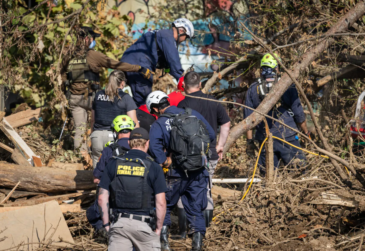 Rescue workers look for bodies after Hurricane Helene in Asheville, N.C., on Oct. 6, 2024. (John Fredricks/The Epoch Times)
