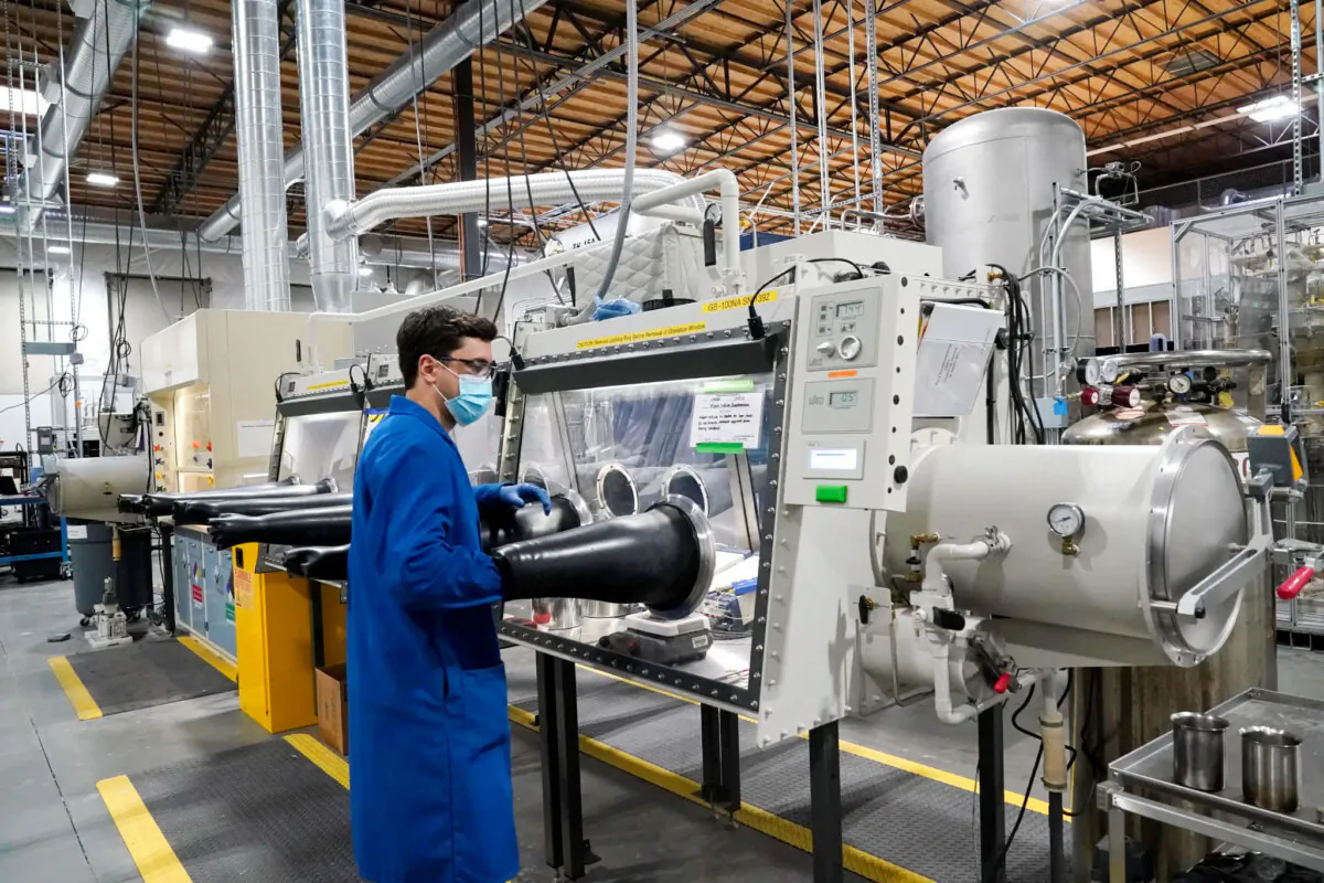 Test engineer Jacob Wilcox pulls his arm out of a glove box used for processing sodium at TerraPower, a company developing and building small nuclear reactors in Everett, Wash., on Jan. 13, 2022. (AP Photo/Elaine Thompson, File)