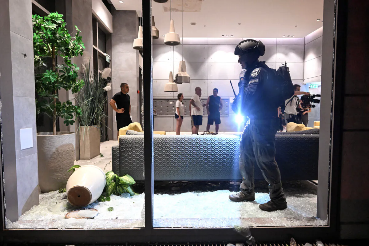 An Israeli police officer inspects the damage to a residential building caused by a rocket fired from Lebanon amid cross-border hostilities between Hezbollah and Israel, in Haifa, Israel, on Oct. 7, 2024. (Rami Shlush/Reutesr)