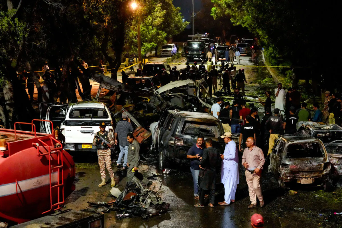 Security officials examine the site of an explosion that caused injuries and destroyed vehicles outside Jinnah International Airport in Karachi, Pakistan, early on Oct. 7, 2024. (Fareed Khan/AP Photo)