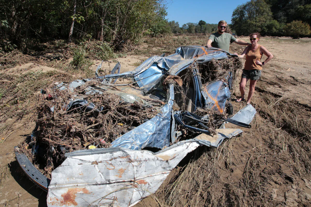 Michael and Brhianna Stapleton with "Plan B," the car that got them to safety from fast-rising floodwaters. Photo taken on Oct. 4, 2024. (Richard Moore/The Epoch Times)
