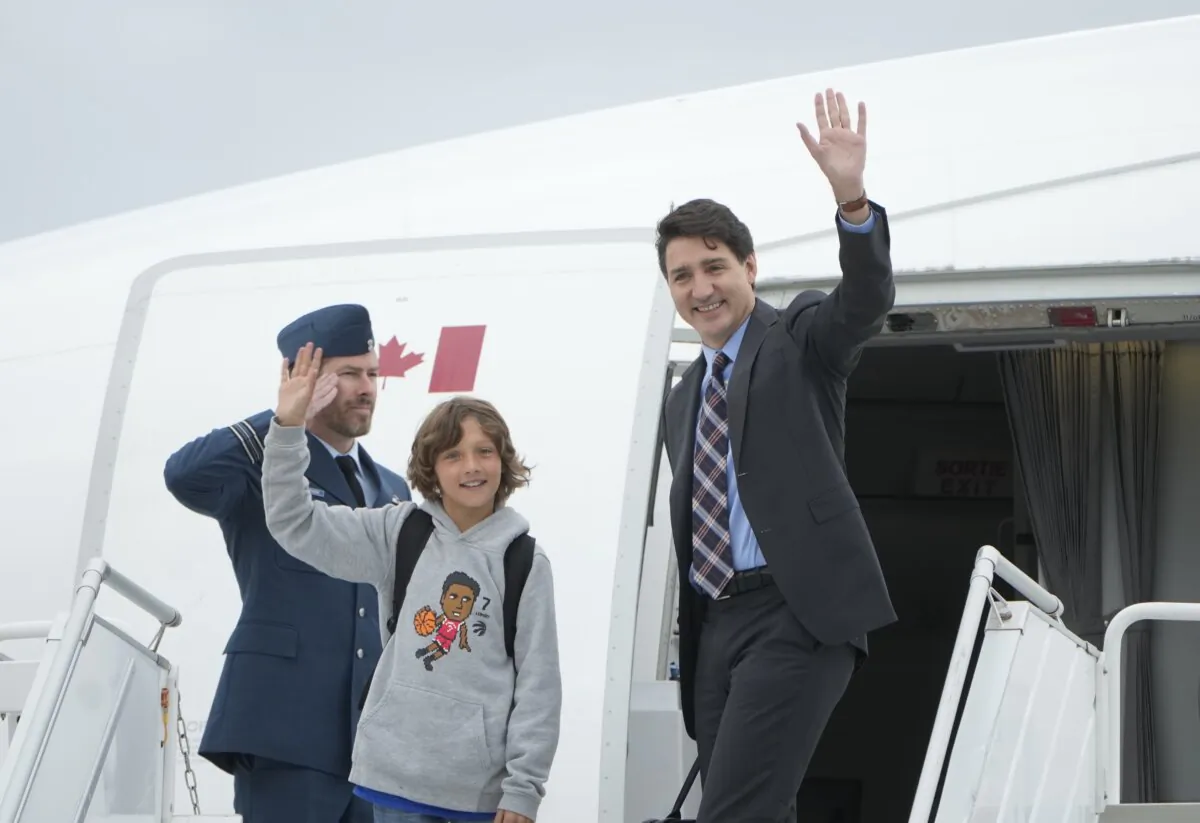Prime Minister Justin Trudeau boards a government plane with his son Hadrien at the airport in Ottawa, on Oct. 8, 2024. (The Canadian Press/Adrian Wyld)