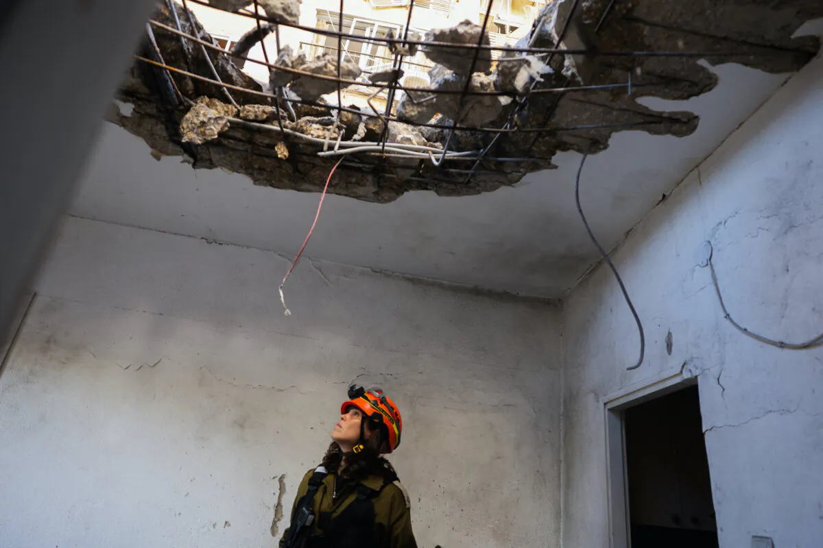 A member of Israeli emergency services inspects a damaged building that was hit with a rocket launched from Lebanon, in Kiryat Yam near Israel's northern city of Haifa on Oct. 8, 2024. (Jack Guez/AFP via Getty Images)