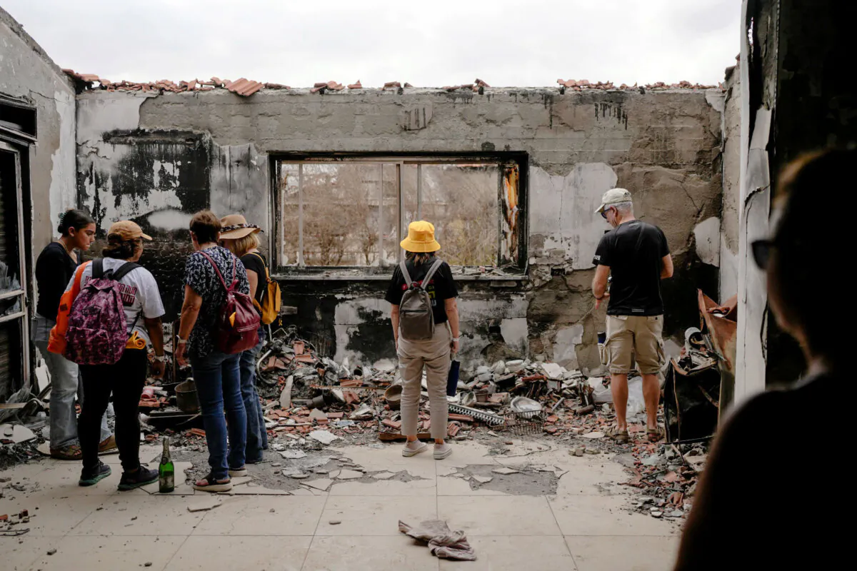 People stand at a battle-scarred home at the Kibbutz Be'eri, an Israeli communal farm on the Gaza border, on Oct. 7, 2024, as Israel marked the one-year anniversary of the Hamas attack on Israel. (AP Photo/Ohad Zwigenberg)
