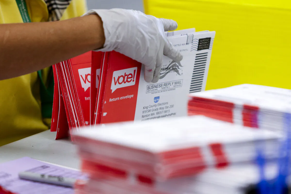 An election worker opens envelopes containing vote-by-mail ballots in a file photo. (Jason Redmond/AFP via Getty Images)
