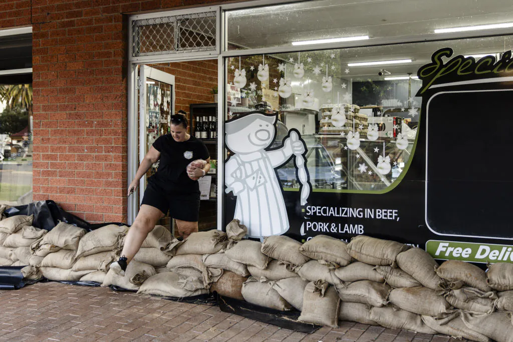 A person uses sandbags to protect a store from floodwater  in Rochester, Australia, on Jan. 9, 2024. (Diego Fedele/Getty Images)