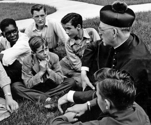 a priest talks with young boys in "Heart of a Servant - The Father Flanagan Story."
