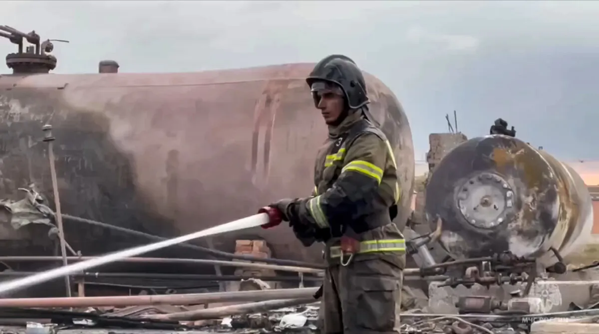 A firefighter extinguishes a large fire after an explosion at a gas station in Grozny, the capital of Chechen republic of Russia, in a still from video released on Oct. 12, 2024. (Russian Emergency Ministry Press Service via AP)