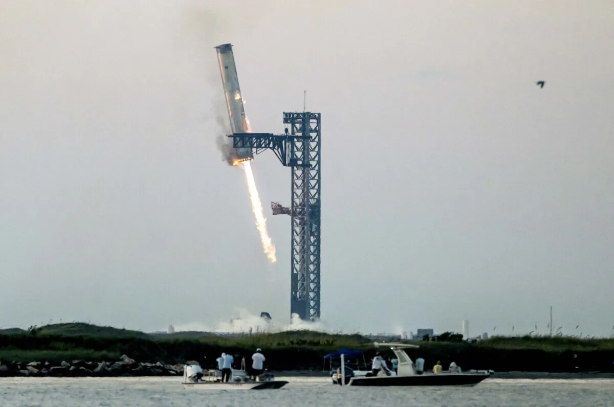 Starship's Super Heavy Booster is grappled at the launch pad in Starbase near Boca Chica, Texas, on Oct. 13, 2024, during the Starship Flight 5 test.  (Seigio Flores/AFP via Getty Images)