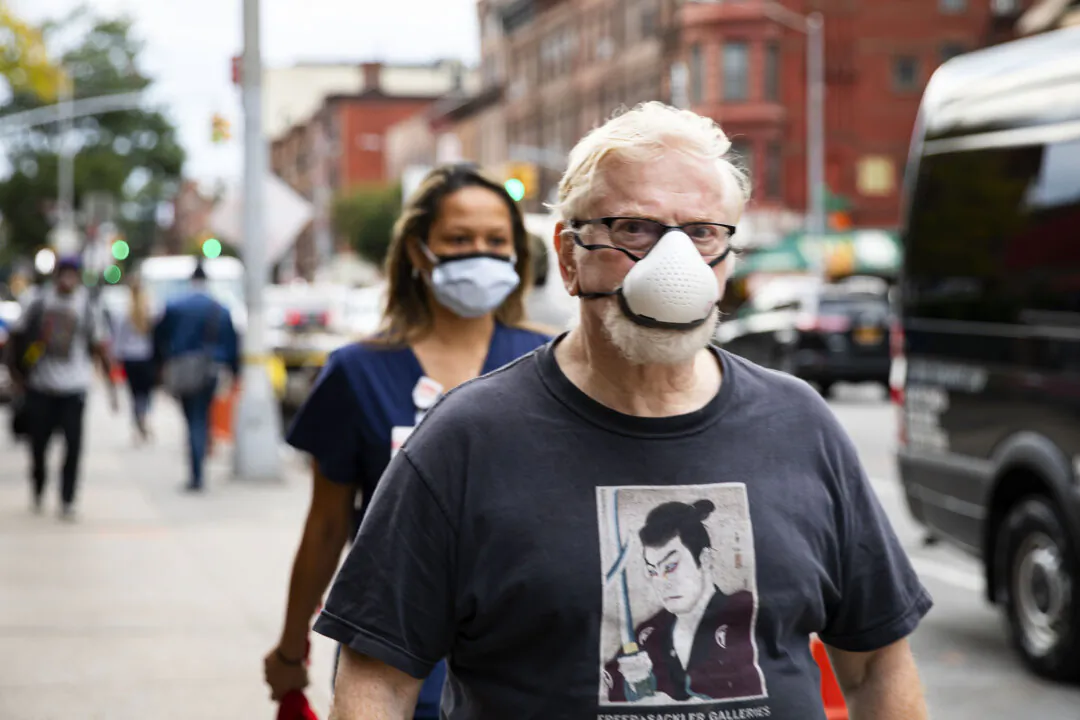 People wearing protective masks walk on the street in a file photo. (Chung I Ho/The Epoch Times)