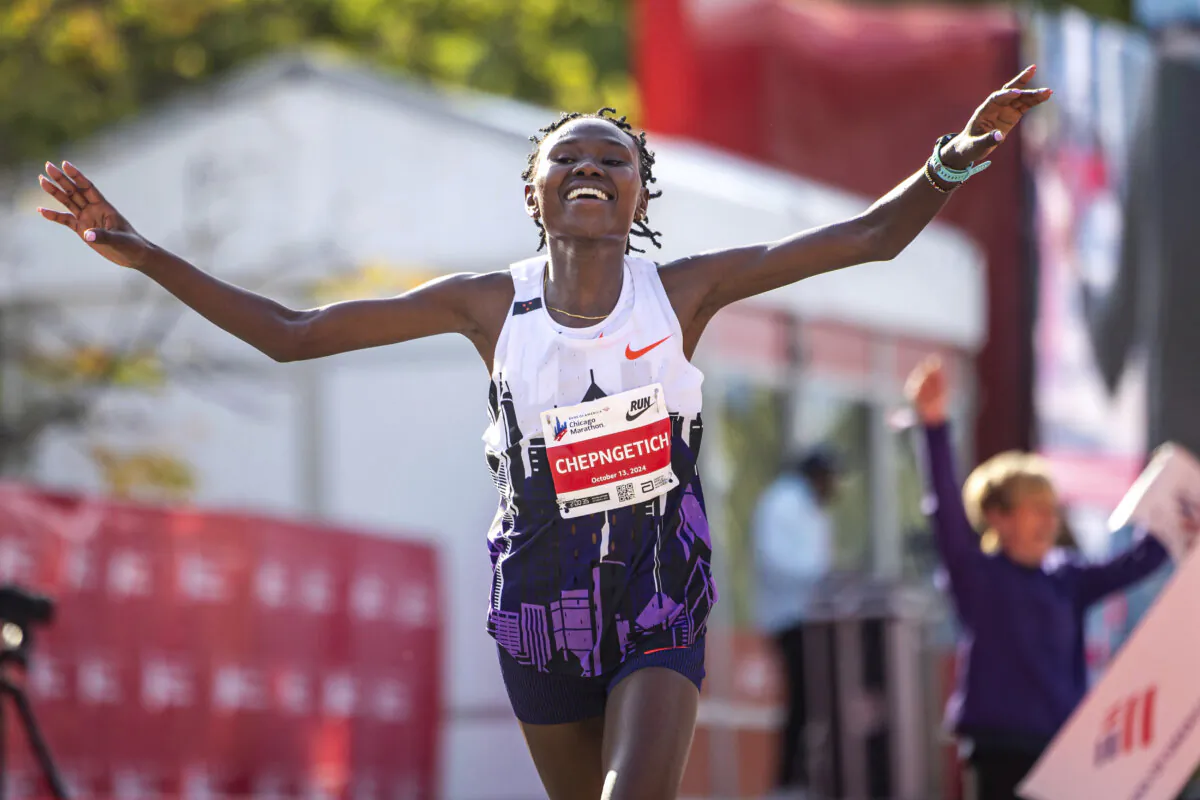 Ruth Chepngetich from Kenya crosses the finish line of the Chicago Marathon to win the women's professional division and break the women's marathon world record in Grant Park on Oct. 13, 2024. (Tess Crowley/Chicago Tribune via AP)