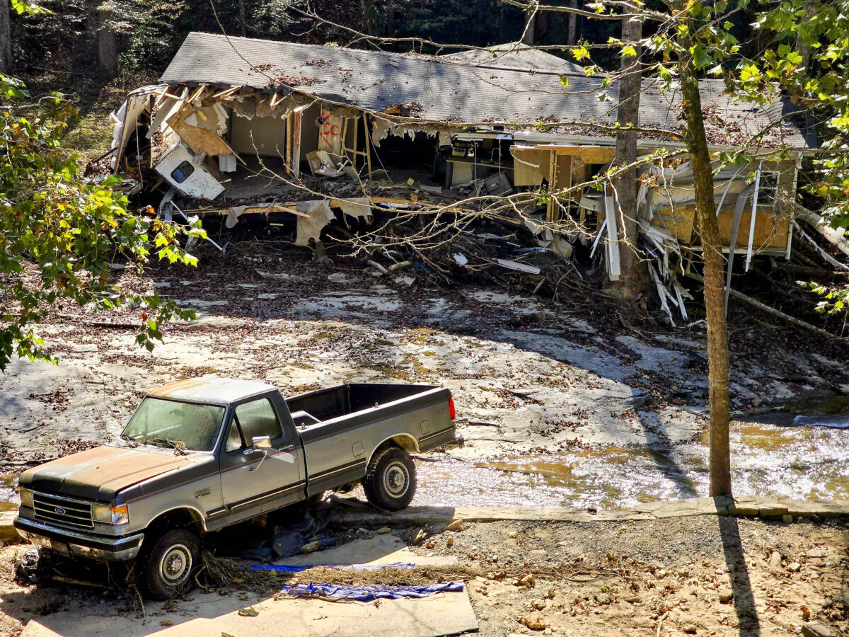 A demolished house and a damaged pickup truck were all that remained in a flood-ravaged area near Asheville, N.C., on Oct. 8, 2024. (Allan Stein/The Epoch Times)