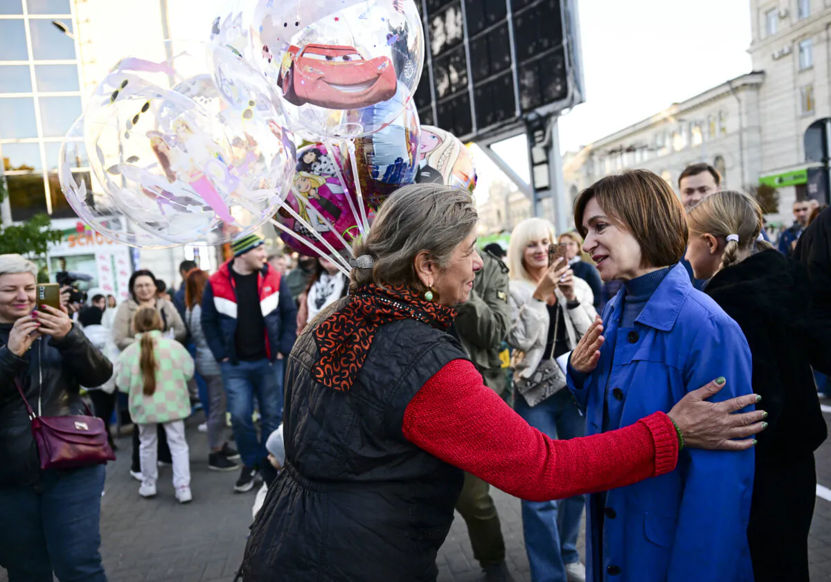 Moldovan President Maia Sandu (R) talks to a woman in Chisinau, Moldova, on Oct. 14, 2024. (Daniel Mihailescu/AFP via Getty Images)
