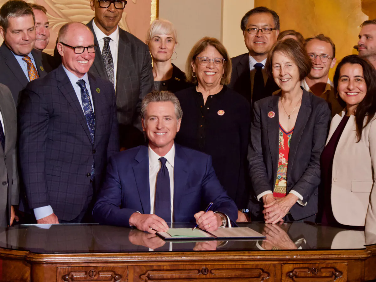 Gov. Gavin Newsom signs Assembly Bill X2-1 regulating oil refiners on Oct. 14 at the Capitol. (Travis Gillmore/The Epoch Times)