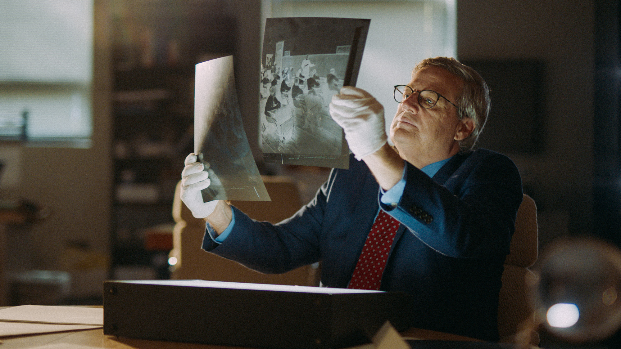 A man looks at photo negatives in in "Heart of a Servant: The Father Flanagan Story." (Spirit Juice Studios)