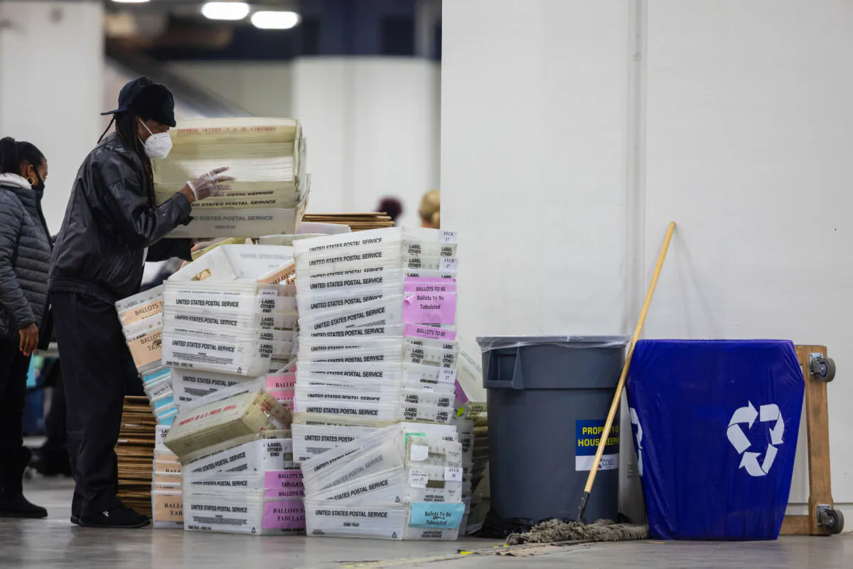A worker with the Detroit Department of Elections helps stack empty boxes used to organize absentee ballots after nearing the end of the absentee ballot count at the Central Counting Board in the TCF Center on Nov. 4, 2020, in Detroit. (Elaine Cromie/Getty Images)