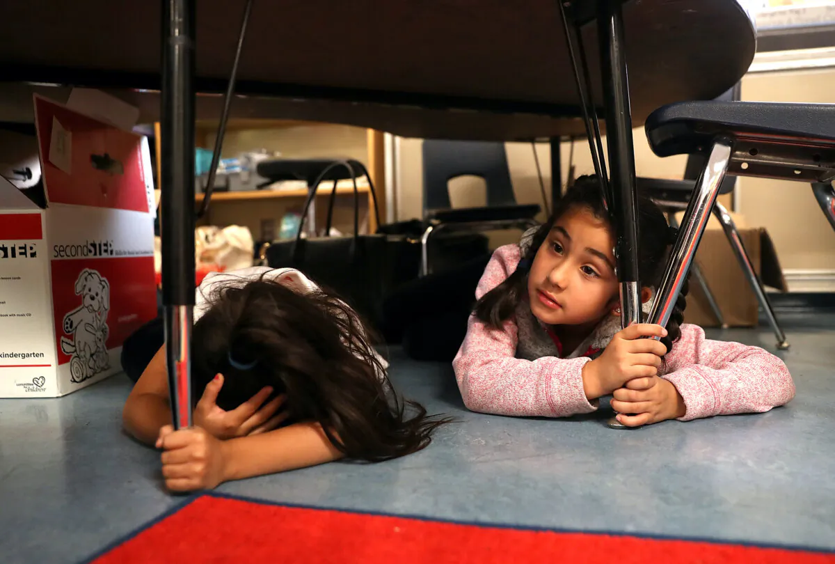 Students at Bryant Elementary School take cover under their desks during an earthquake drill as part of the Great ShakeOut event in San Francisco on October 18, 2018. (Justin Sullivan/Getty Images)