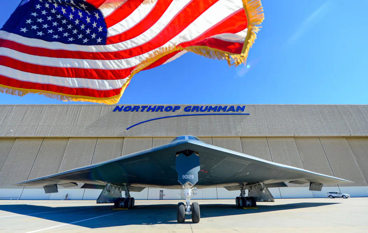 A U.S. flag flies beside a B-2 Stealth Bomber at the Palmdale Aircraft Integration Center of Excellence in Palmdale, Calif., on July 17, 2014. (Frederic J. Brown/AFP via Getty Images)