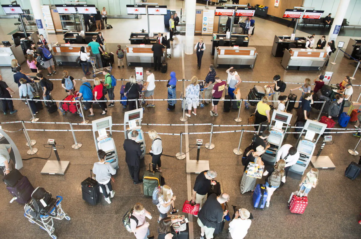 Passengers wait to check-in at Trudeau Airport on July 19, 2017 in Montreal. (The Canadian Press/Ryan Remiorz)
