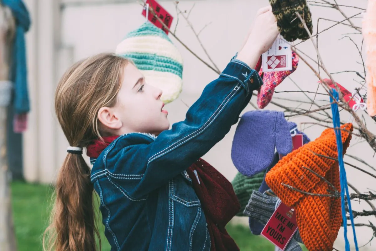 A girl puts up colorful crafts made by Warm Up America!
volunteers across the country. (Hard Knoch PR)