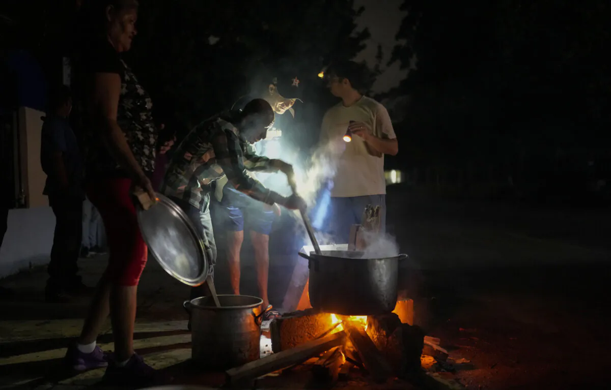 Residents prepare a soup over an open fire during a blackout following the failure of a major power plant in Havana, Cuba, on Oct. 19, 2024. (Ramon Espinosa/AP Photo)