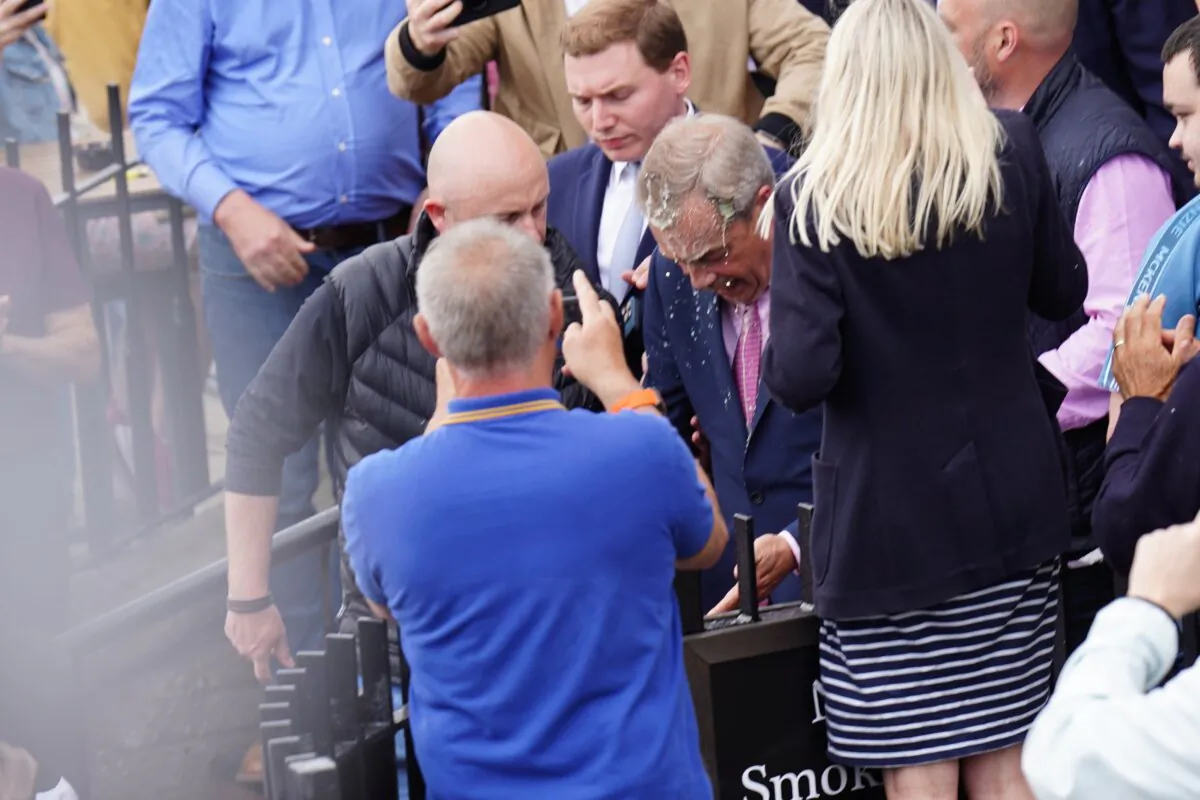 Leader of Reform UK Nigel Farage has a drink thrown over him as he leaves the Moon and Starfish pub in Essex on June 4, 2024. (James Manning/PA)
