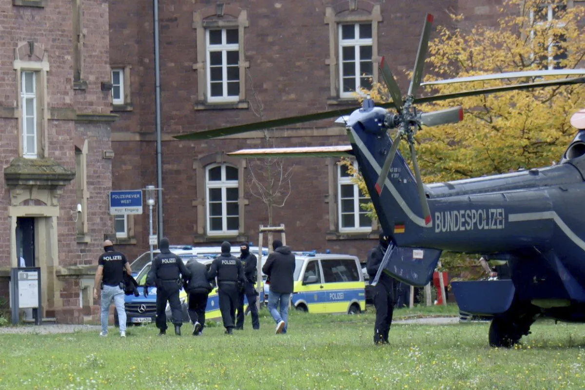 Police officers escort a Libyan national with suspected ties to the extremist group Islamic State who was allegedly planning an attack on the Israeli Embassy in Berlin, in Karlsruhe, Germany, Oct. 20, 2024. (Rene Priebe/dpa via AP)