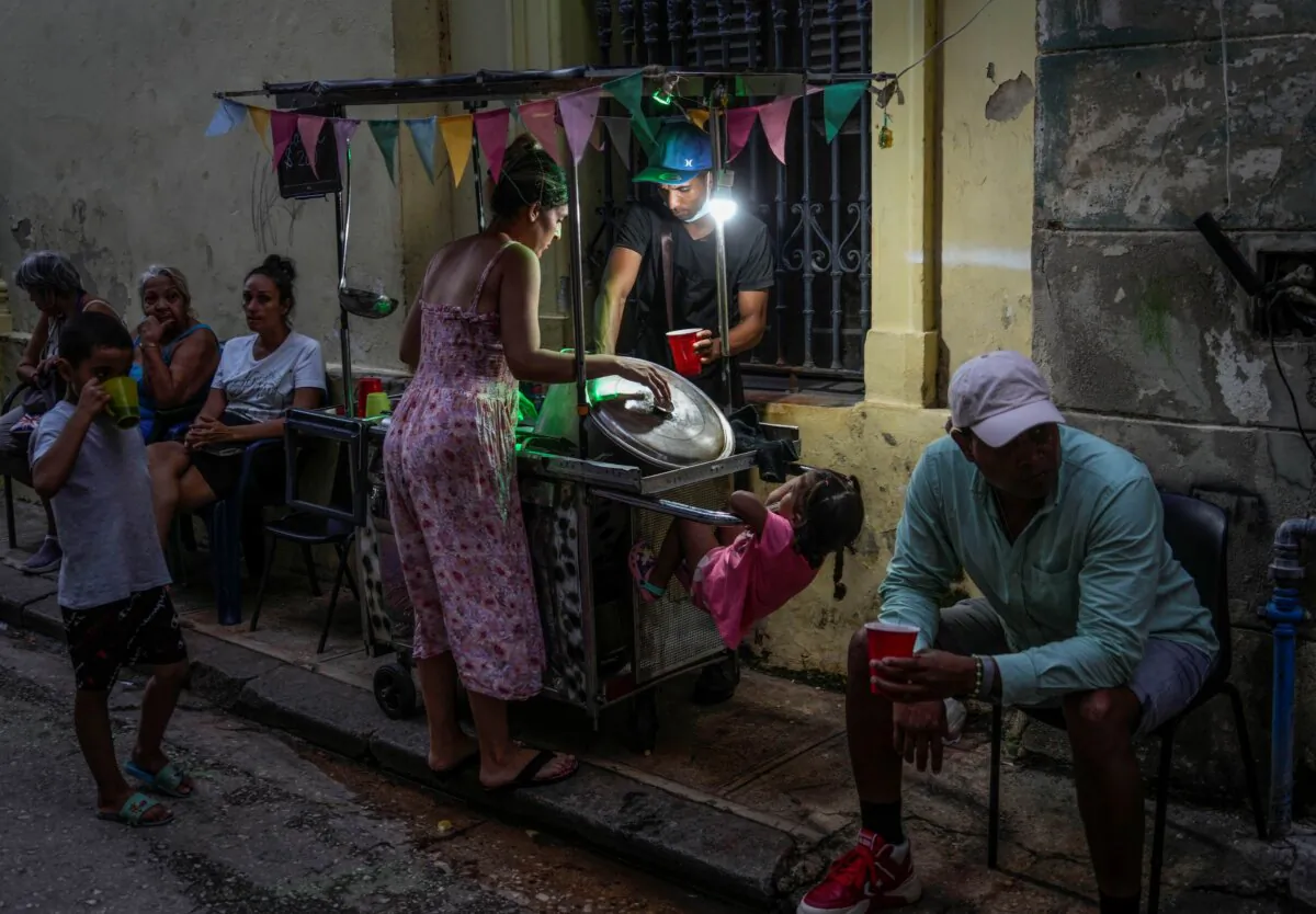 A woman buys soup from a street vendor during a power outage in Havana on Oct. 21, 2024. (Ramon Espinosa/AP Photo)