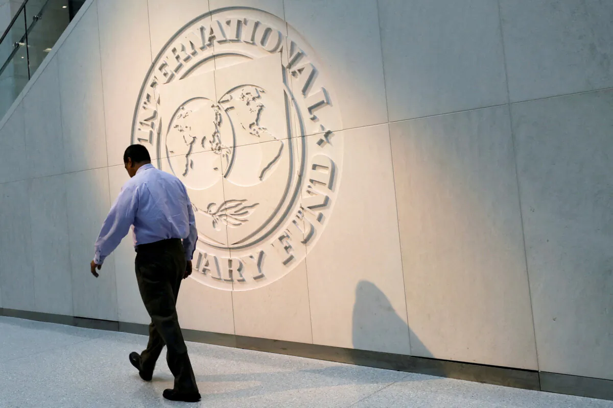 A man walks past the International Monetary Fund (IMF) logo at its headquarters in Washington on May 10, 2018. (Yuri Gripas/Reuters)