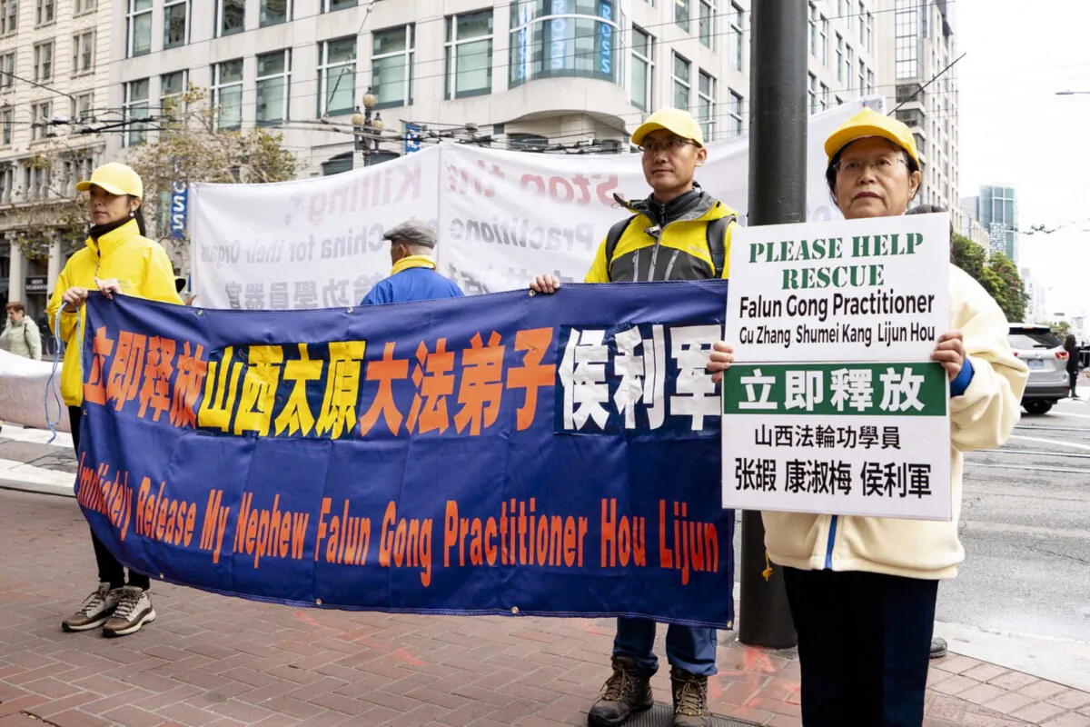 Karen Kang holds a placard calling for help to secure the release of three Falun Gong practitioners, including her nephew Hou Lijun, during a protest in San Francisco on Nov. 15, 2023. (Courtesy of Minghui.org)