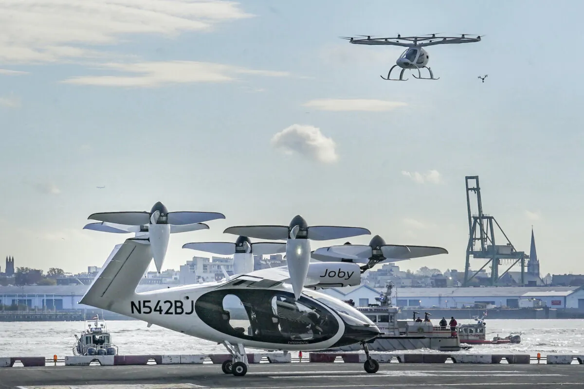 An electric vertical takeoff and landing (eVTOL) aircraft, flies above the Joby eVTOL aircraft, during a demonstration of eVTOLs in New York on Nov. 13, 2023. (Bebeto Matthews/AP Photo)