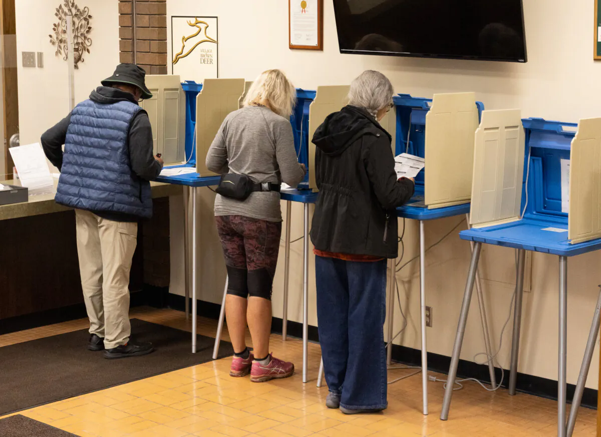 People complete their early voting ballots in Brown Deer, Wis., on Oct, 22, 2024. (John Fredricks/The Epoch Times)