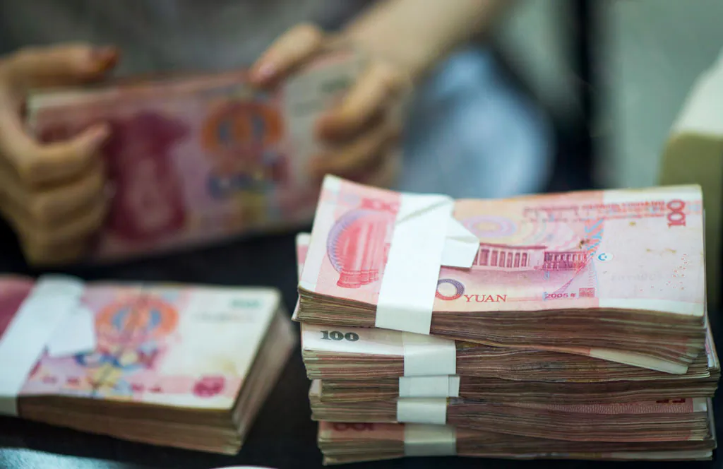 A worker counts currency in a bank in Shanghai. There have been a string of failures by private lending firms in China, leaving those who had invested their savings in the companies protesting to get their money back. (Johannes Eisele/AFP/Getty Images)