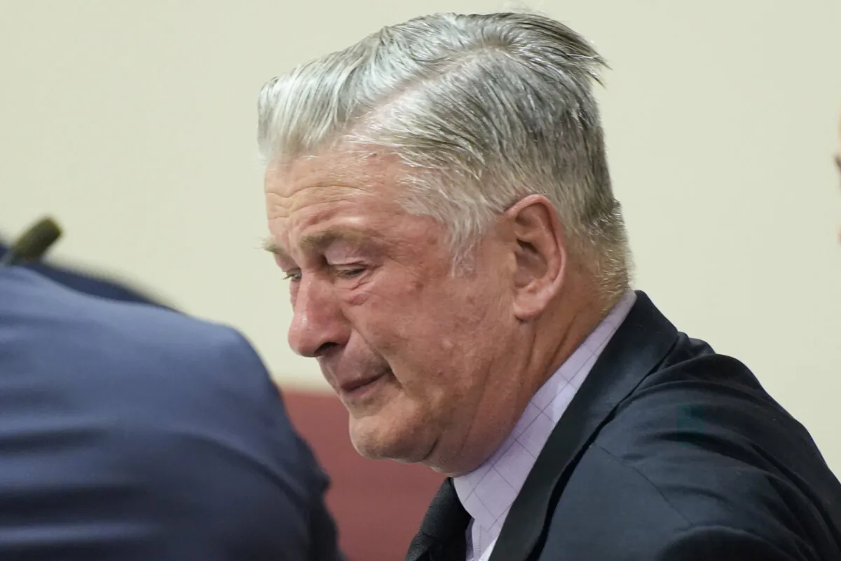 Actor Alec Baldwin, center, reacts as he sits between his attorneys Alex Spiro, left, and Luke Nikas after the judge threw out the involuntary manslaughter case for the 2021 fatal shooting of cinematographer Halyna Hutchins during filming of the Western movie "Rust," Friday, July 12, 2024, in Santa Fe, N.M.   (Ramsay de Give/Pool Photo via AP)