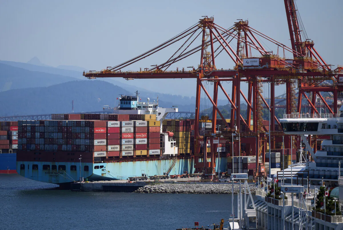 A gantry crane operator removes a container from a cargo ship while docked at port, in Vancouver, on July 16, 2024. (The Canadian Press/Darryl Dyck)