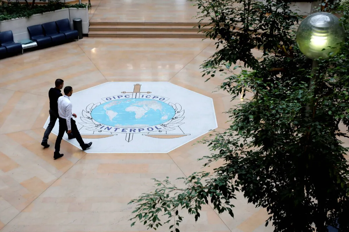 People walk through the entrance hall of INTERPOL's headquarters in Lyon, central France, on Nov. 8, 2018. (AP Photo/Laurent Cipriani)