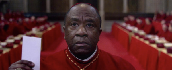 A cardinal with a white piece of paper in Conclave