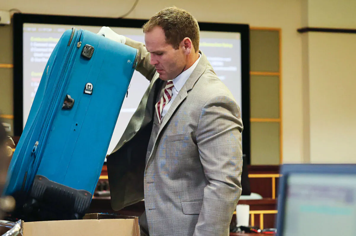 Prosecutor Dave Cacciatore Jr. takes out the suitcase in evidence as he begins the closing arguments in Defendant Sarah Boone's trial, Friday, Oct. 25, 2024, at the Orange County Courthouse in Orlando, Fla. Boone is charged with leaving her boyfriend to die after he was zipped into a suitcase in their home, (Ricardo Ramirez Buxeda/Orlando Sentinel via AP, Pool)