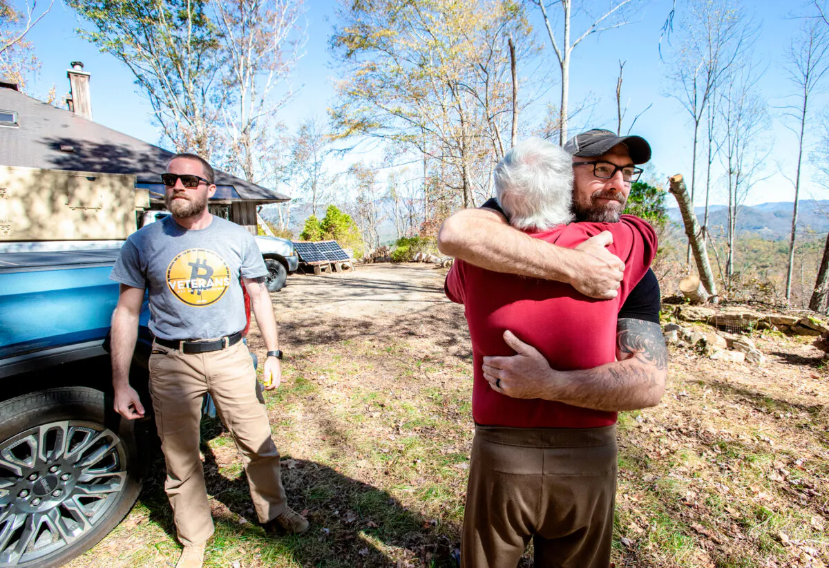 Shane Hazel hugs John Kruppenbach during a visit to his home in North Carolina on Oct. 20, 2024. Hazel and his Bitcoin Veteran organization helped residents in the early aftermath of the storm. (Bobby Sanchez/The Epoch Times)