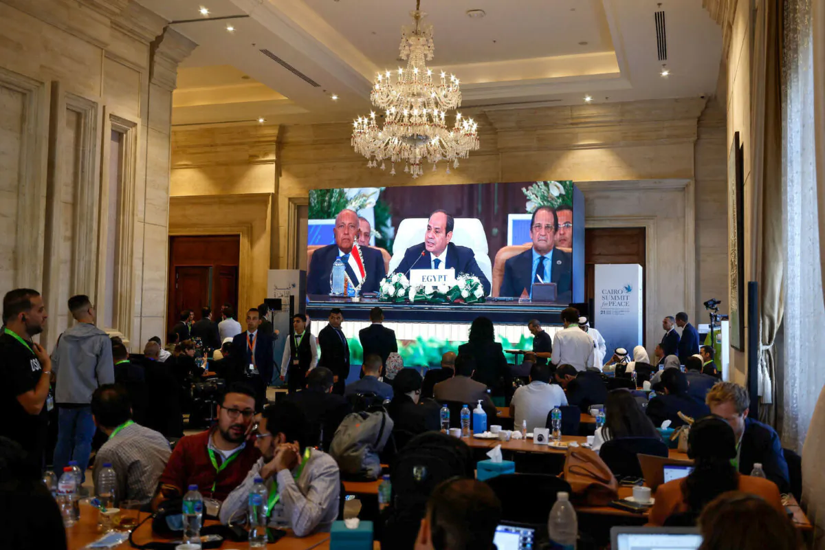 People watch a large screen as Egyptian President Abdel-Fattah al-Sisi opens the International Peace Summit in Cairo on Oct. 21, 2023. (Khaled Desouki/AFP via Getty Images)