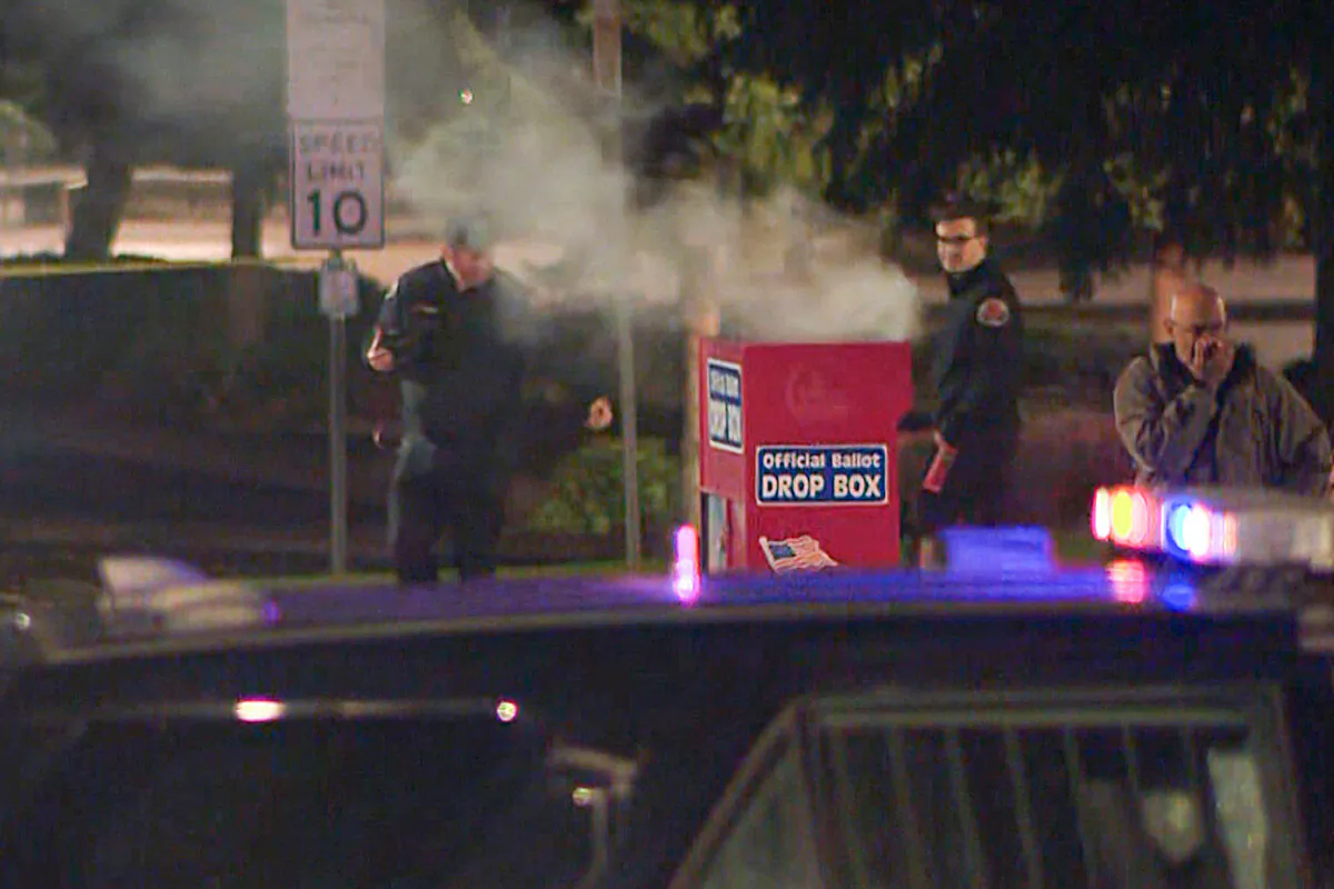 Authorities investigate smoke pouring out of a ballot box in Vancouver, Wash., on Oct. 28, 2024, in a still from video. (KGW8 via AP)