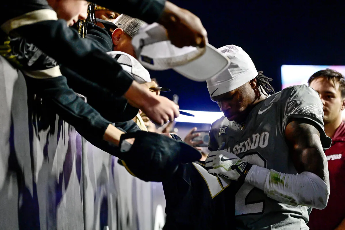 Travis Hunter #12 of the Colorado Buffaloes signs autographs for supporters after a win in a game  at Folsom Field  in Boulder, Colorado on October 26, 2024. (Dustin Bradford/Getty Images)