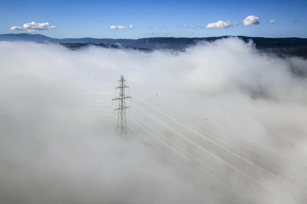 Aerial photograph of an electricity pylon emerging from fog near Gimel, western Switzerland, on Oct. 29, 2024. (Fabrice Coffrini /AFP)