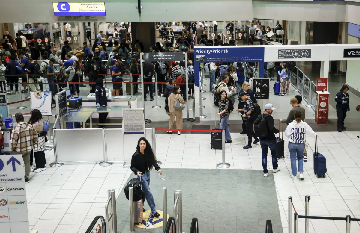 Passengers line-up to pass through security at the Calgary International Airport on Aug. 6, 2024. (The Canadian Press/Jeff McIntosh)