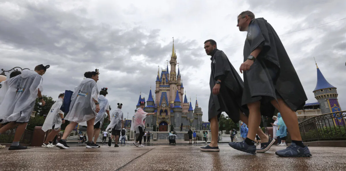 Guests weather early bands of rain from Hurricane Milton at the Magic Kingdom at Walt Disney World in Bay Lake, Fla., on Oct. 9, 2024. (Joe Burbank/Orlando Sentinel via AP)