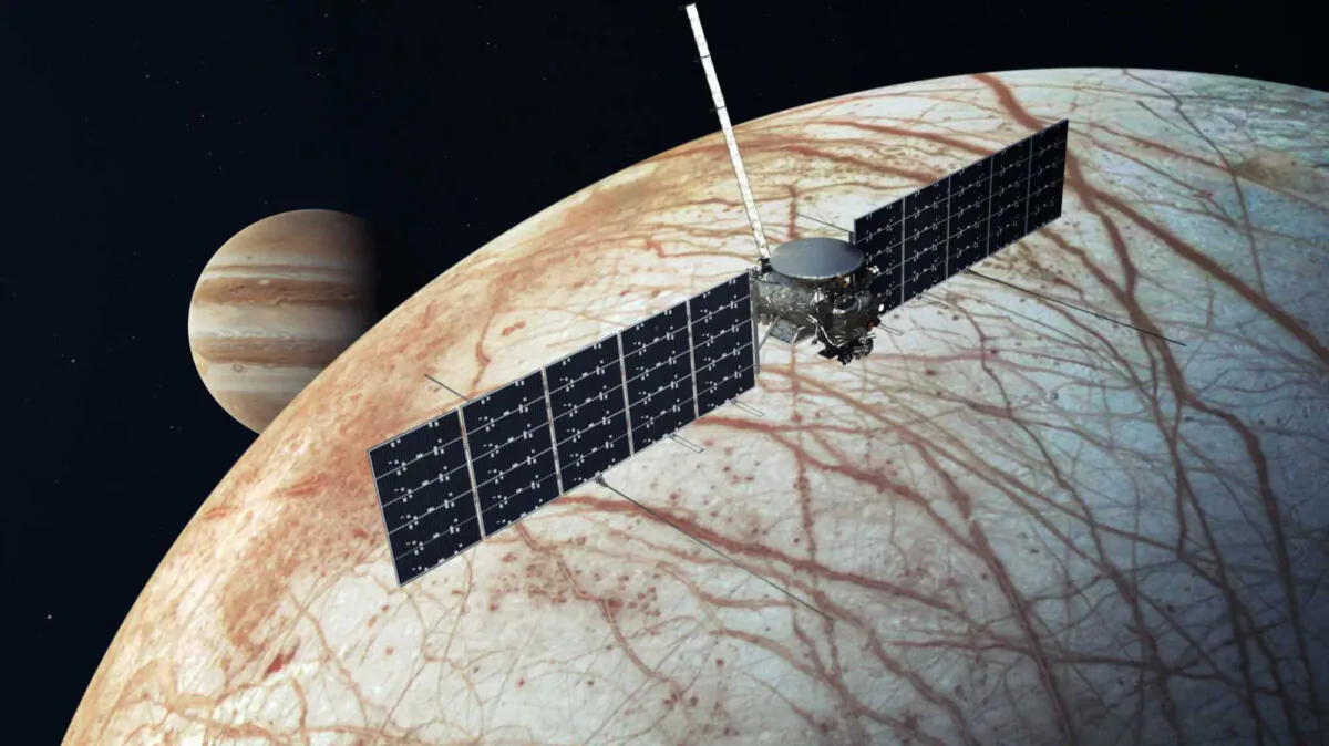 An illustration shows the Europa Clipper spacecraft over the moon Europa with Jupiter at background (L). (NASA/JPL-Caltech via AP)