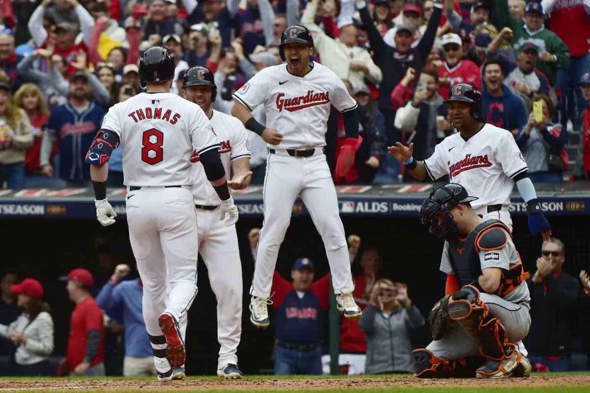 Cleveland Guardians players, from rear left, David Fry, Steven Kwan and Jose Ramirez greet teammate Lane Thomas after Thomas hit a grand slam in the fifth inning during Game 5 of baseball's American League Division Series against the Detroit Tigers, Saturday, Oct. 12, 2024, in Cleveland. Tigers catcher Jake Rogers is at right. (AP Photo/Phil Long)